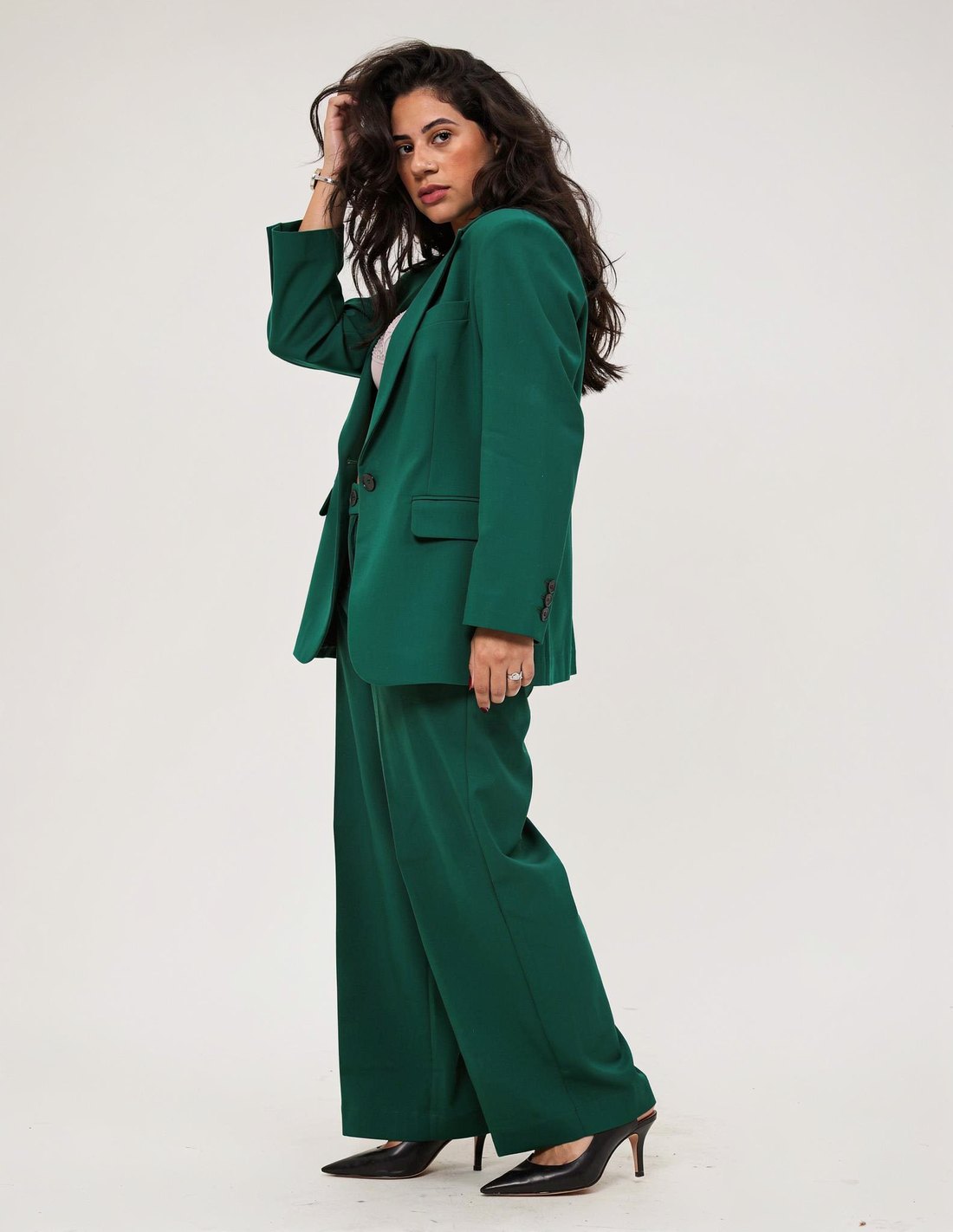 Yasmin Reis em terno verde, pose dinâmica